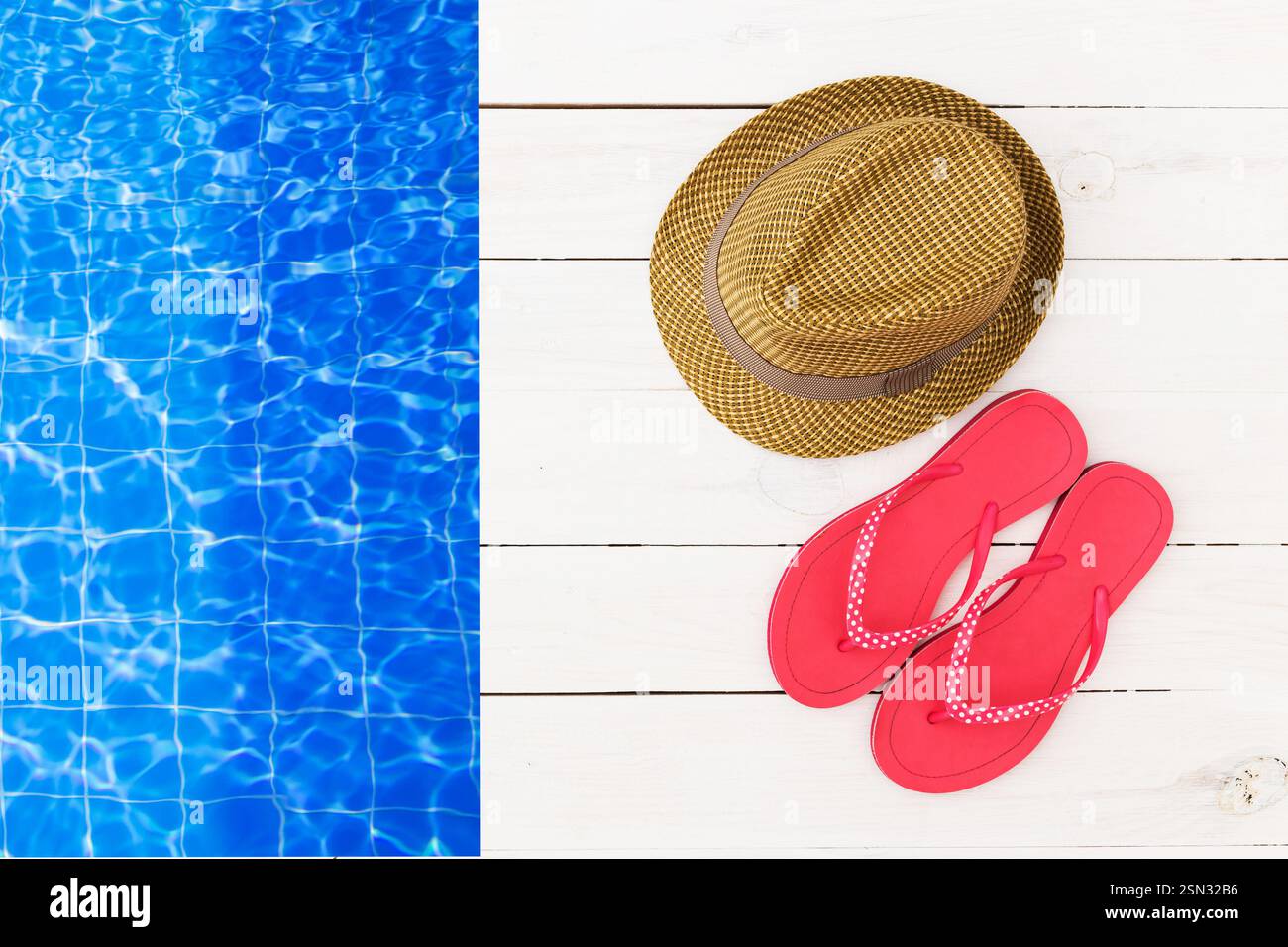 Relaxing summer getaway with pink flip flops and a straw hat beside a ...