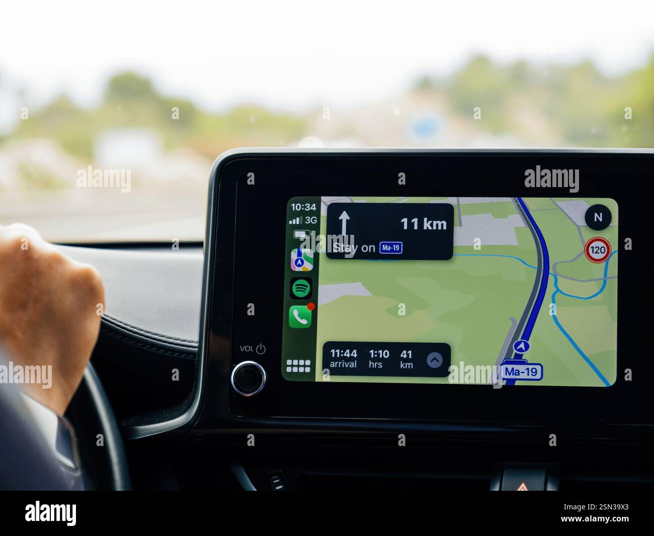 Mallorca, Spain - Jun 28, 2023: A close-up of a car's infotainment screen displaying CarPlay navigation on highway Ma-19 in Mallorca, showing directio Stock Photo