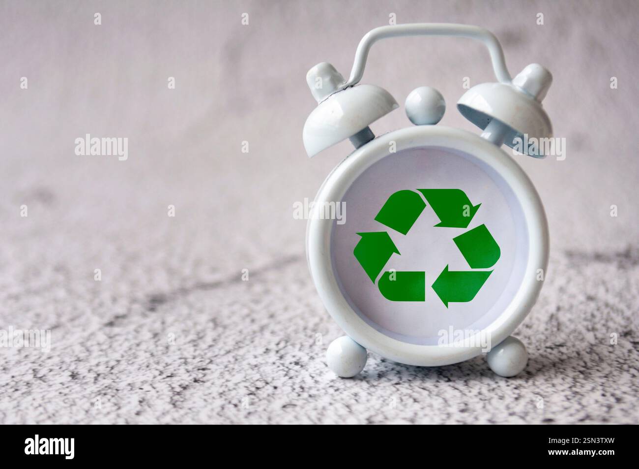 Recycle symbol on white alarm clock with customizable space for text or ideas Stock Photo