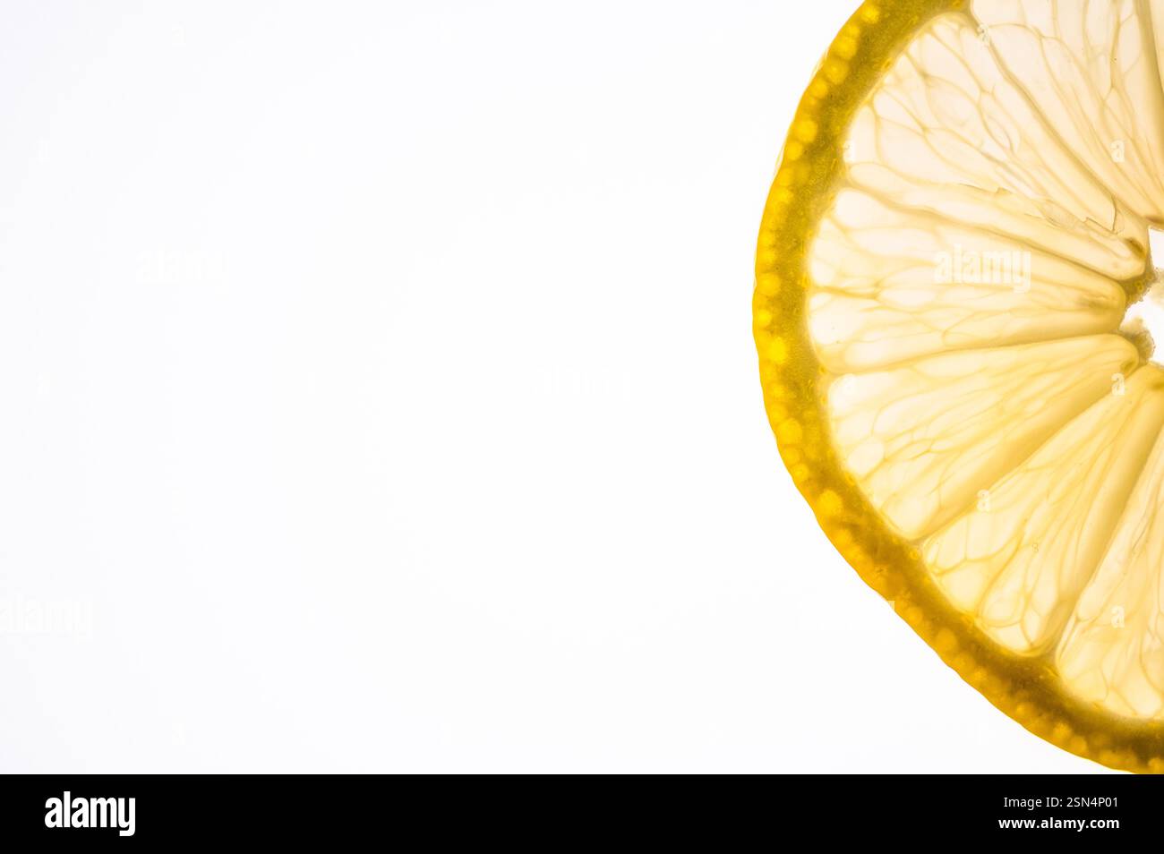 Thin slice of lemon backlit on a white background Stock Photo