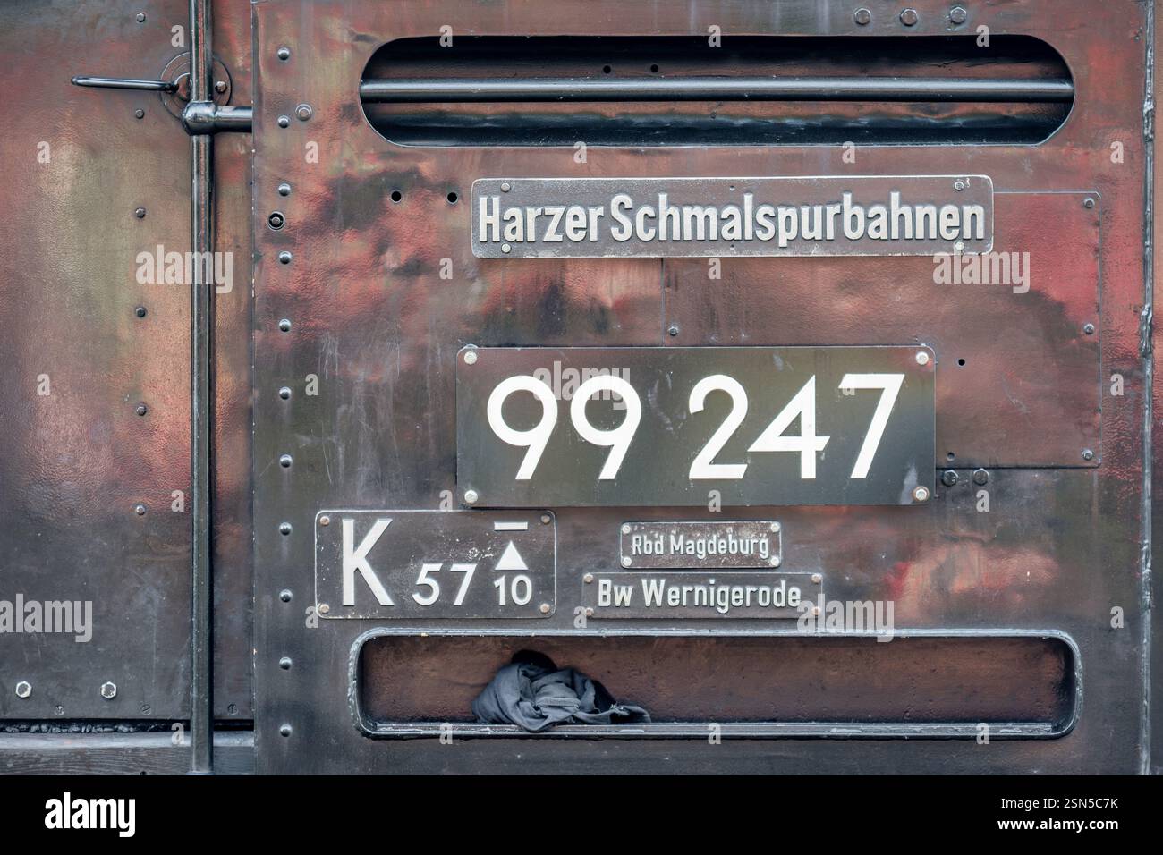 On the side of a Brockenbahn steam locomotive, its unique license plate is attached. It is part of the Harzer schmalspurbahn. Stock Photo