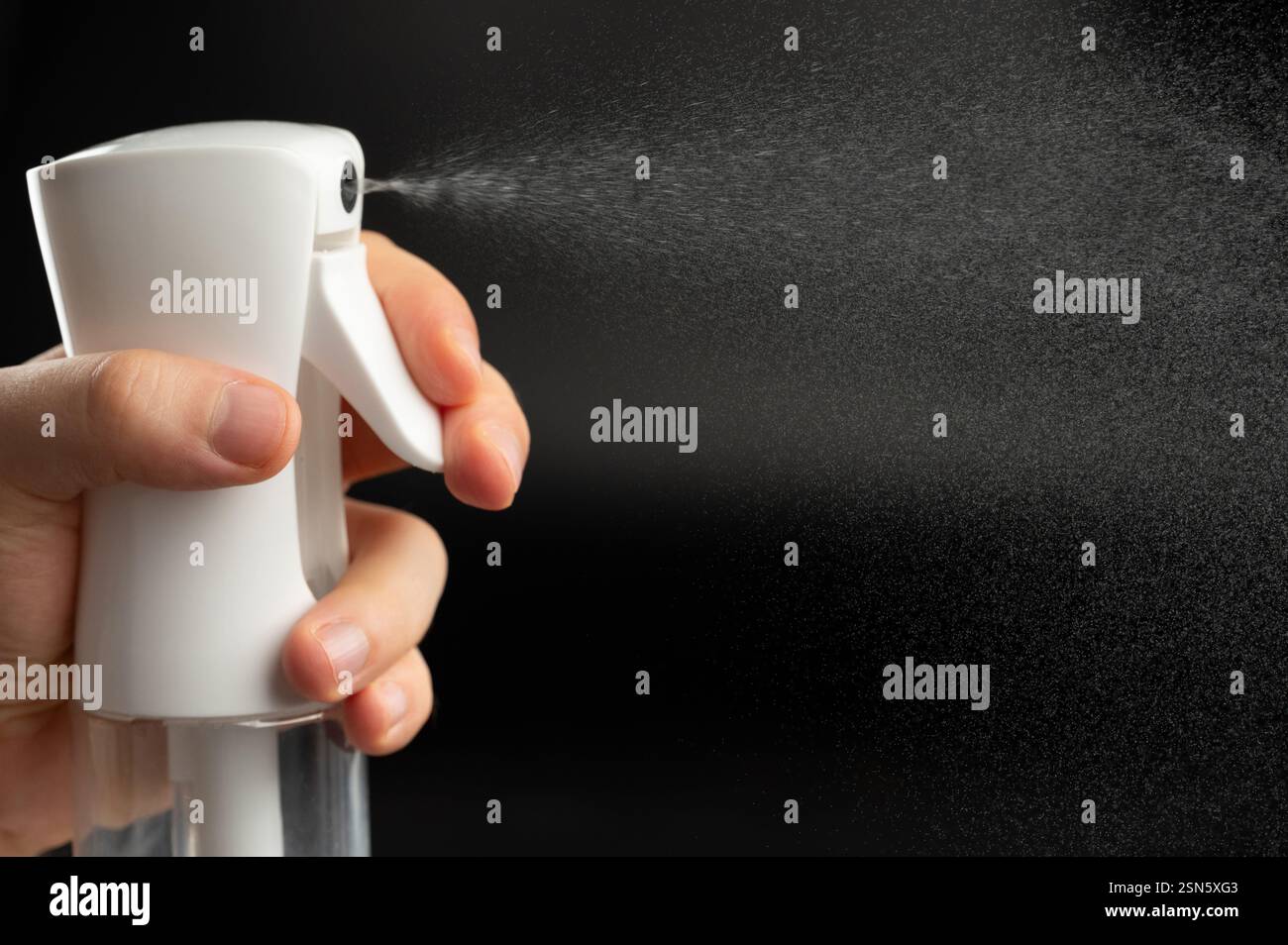 Water spray jet on black background from plastic bottle close up view Stock Photo