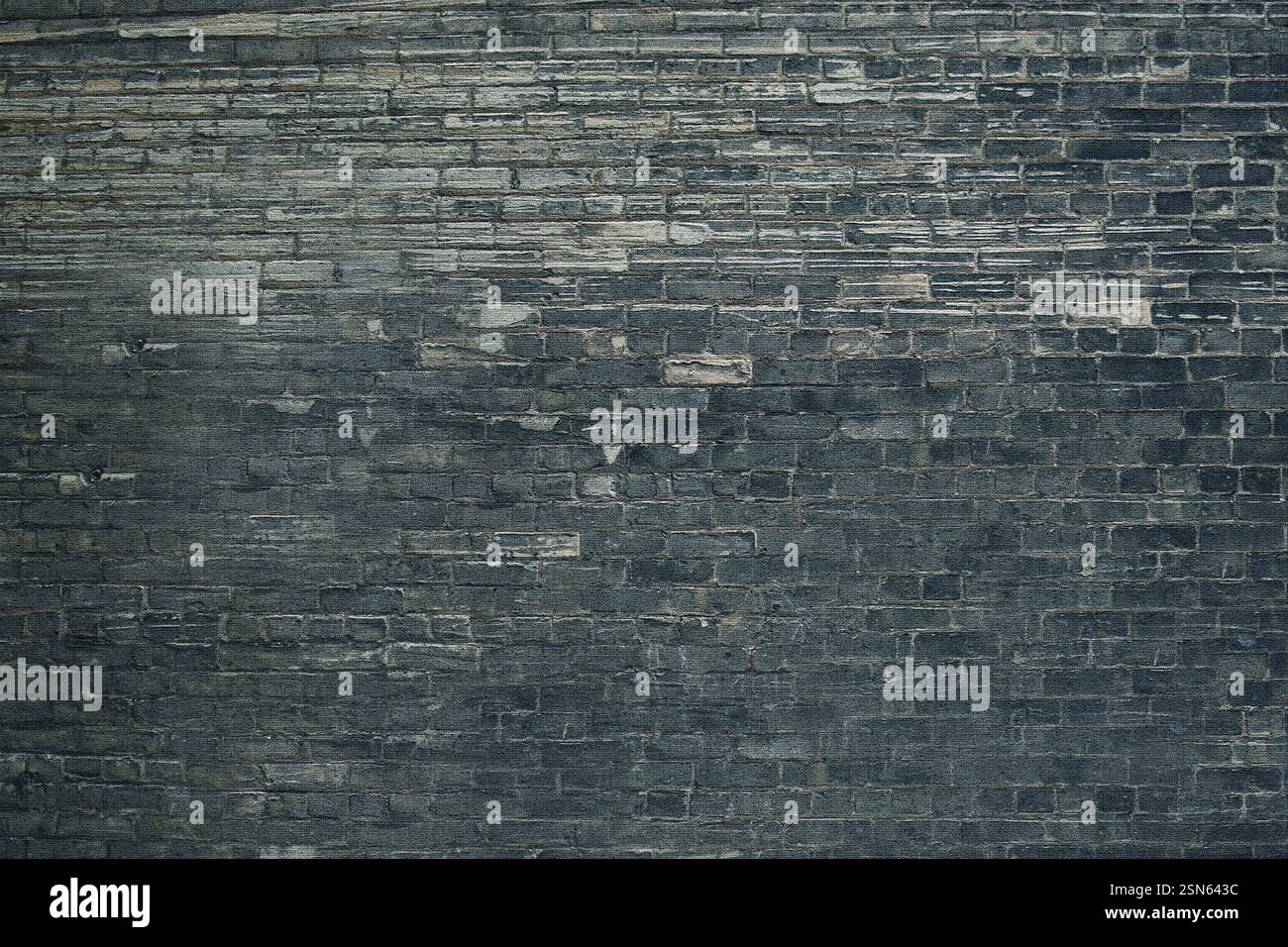 Dark gray brick wall forming a textured background Stock Photo
