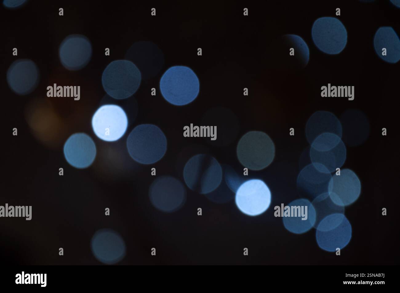 A blurry, out-of-focus image shows light circles of various shades of blue and light gray. These are likely the light from various sources. Stock Photo