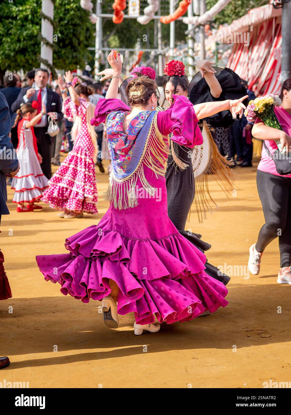Two women dressed in traditional attire, dancing Sevillanas at Seville