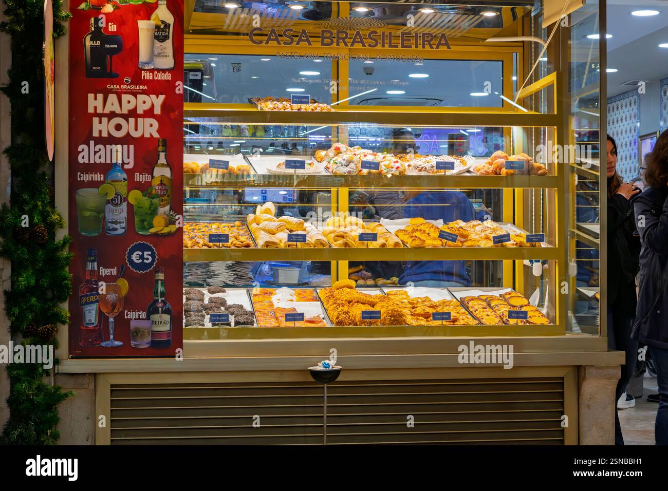 A display window case with bread, desserts, dried meats and pastries at a gourmet bakery and market at night, in Lisbon Portugal. Stock Photo