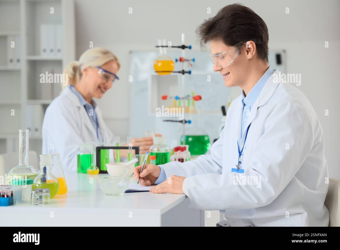 Male chemist working at table in laboratory Stock Photo