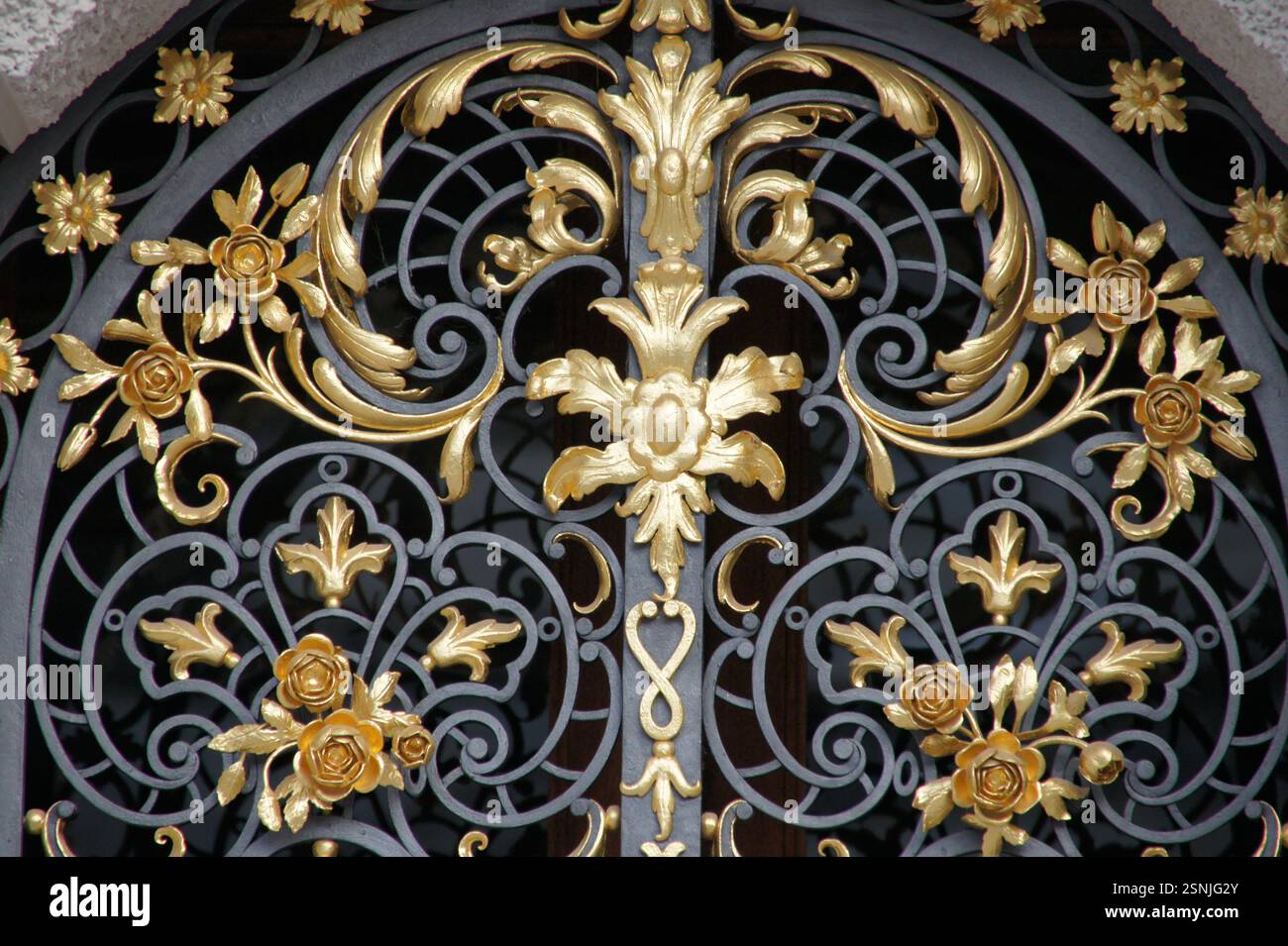 Germany, Munich. An ornate wrought iron gate with intricate gold ...