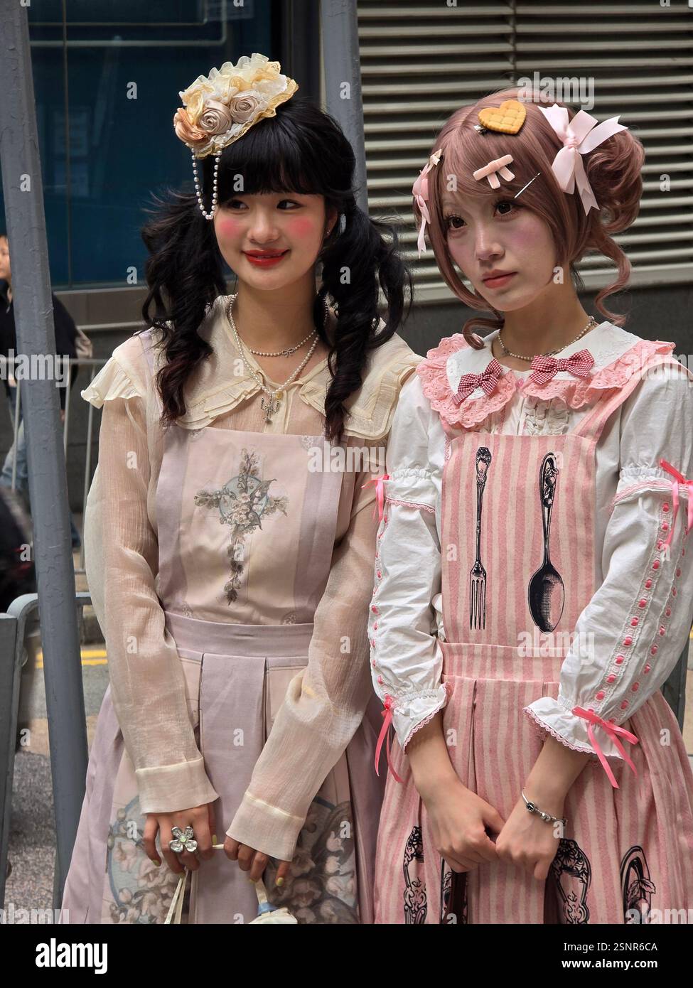 Young women in Lolita-style outfits posing for a photo in Hong Kong's Central district. - Smartphone Captured Stock Image