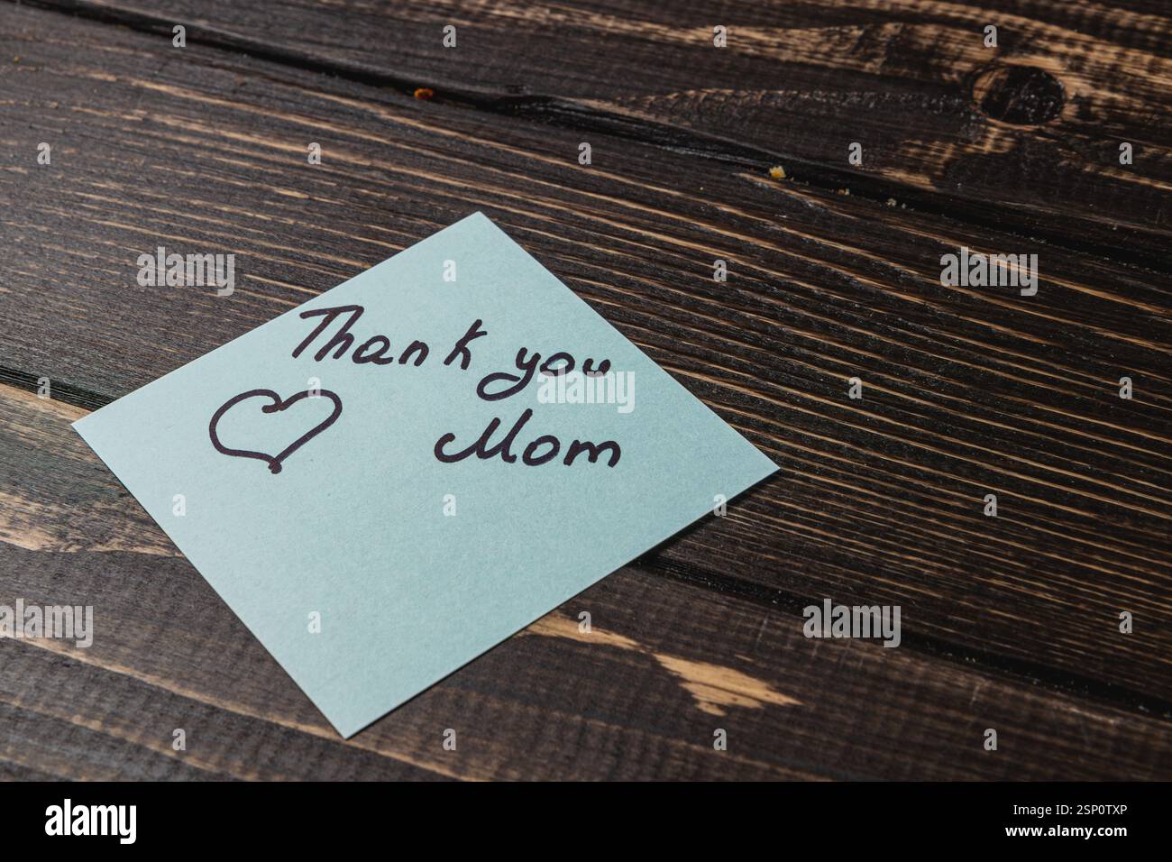 Rustic Sticky Note A light blue sticky note rests on a rustic wooden table, featuring a ...