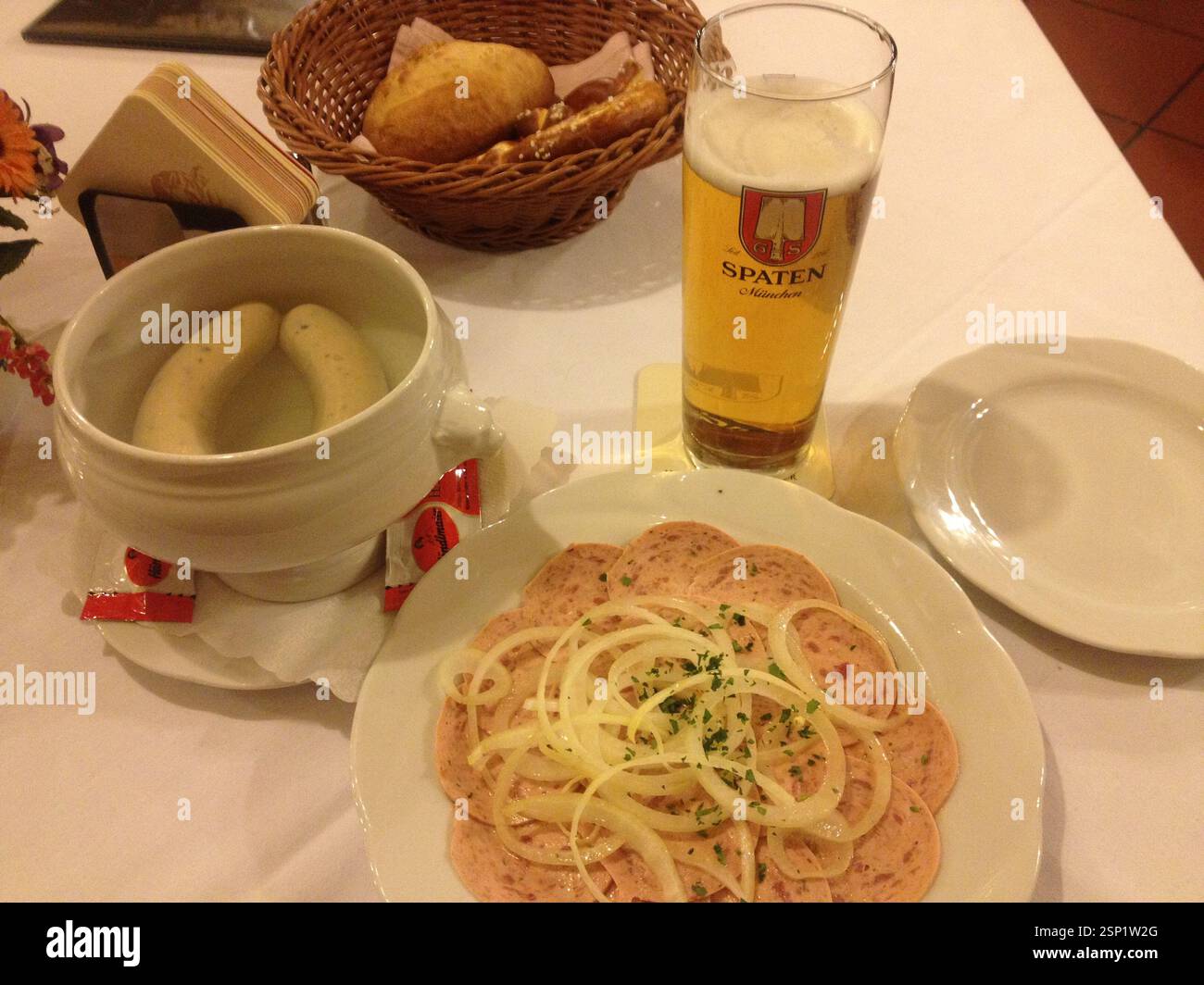 Bavarian feast: crispy white sausages, tangy sweet mustard, frothy Spaten beer, perfect culinary journey Germany, Munich. Traditional German hospitali Stock Photo