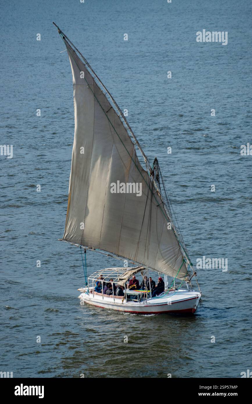 A traditional boat sailing on the Nile River in Egypt, capturing the ...