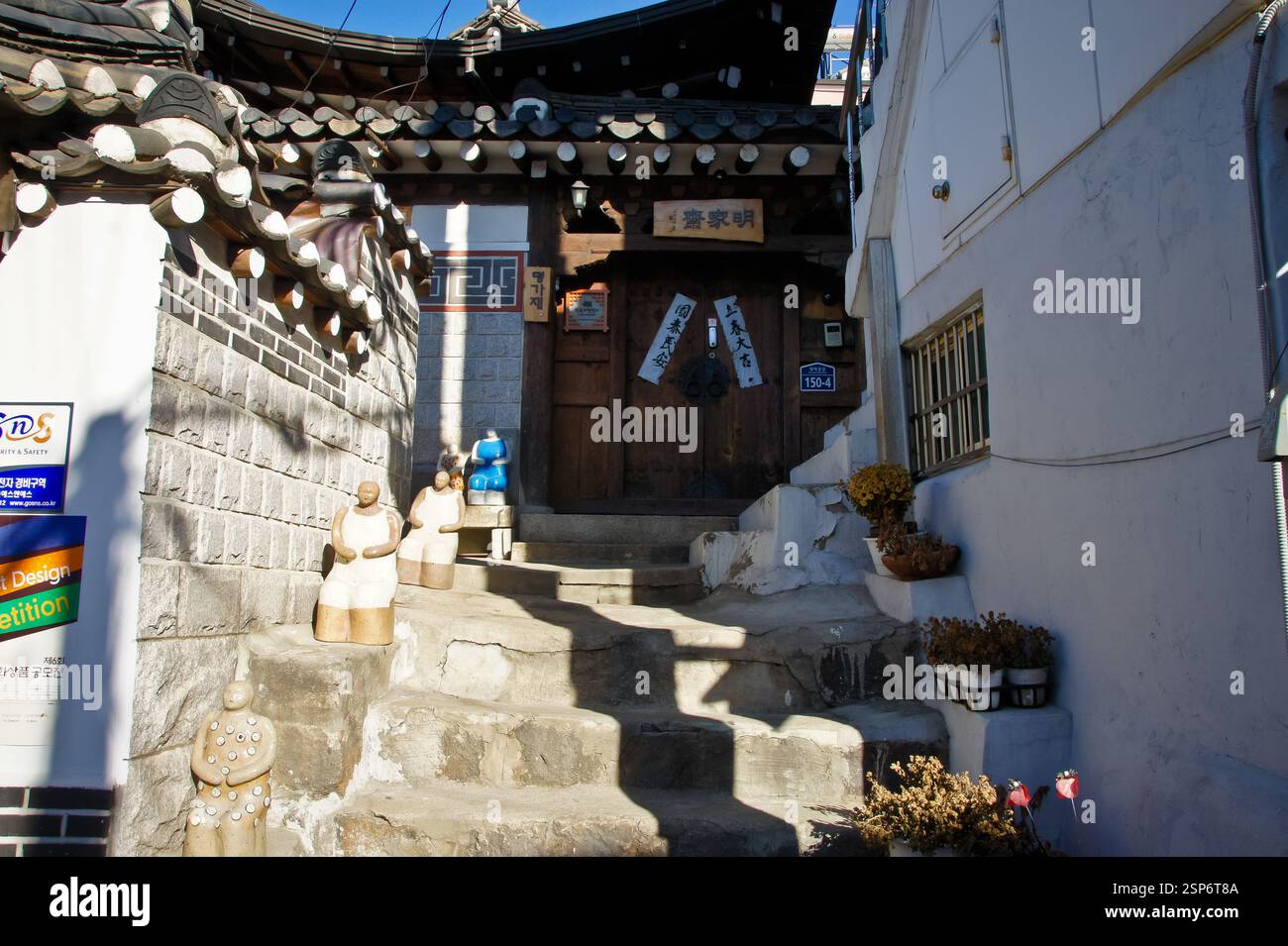 Korean alleyway. Hanok house with tiled roof and wooden door. Stone ...