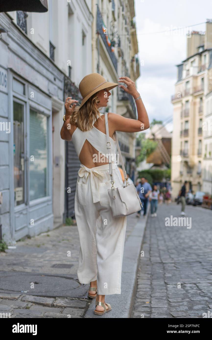 Woman in Straw Hat Exploring Paris Streets in Casual Fashion. Stock Photo
