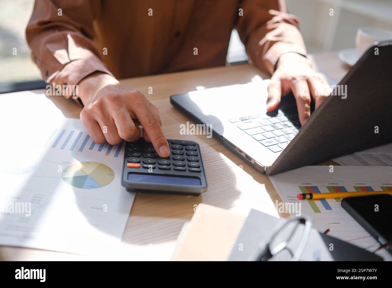 Accountant working on financial calculations using a calculator Stock Photo