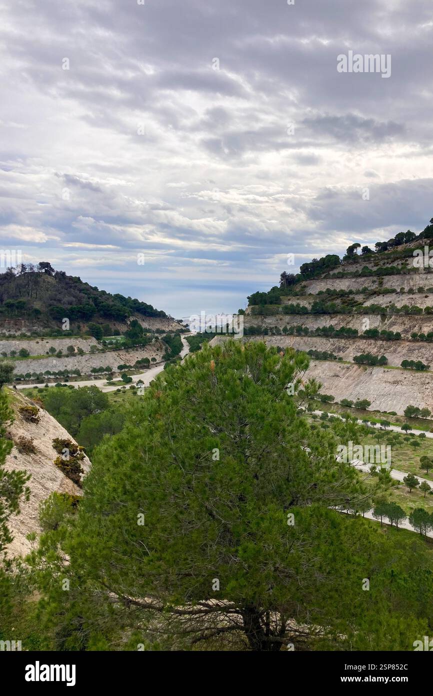Hiking on trail along abandoned open-pit mine and burnt trees near Mijas, Spain - Smartphone Captured Stock Image
