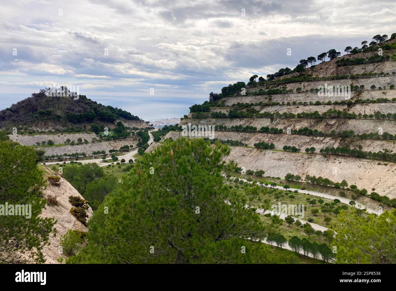 Hiking on trail along abandoned open-pit mine and burnt trees near Mijas, Spain - Smartphone Captured Stock Image