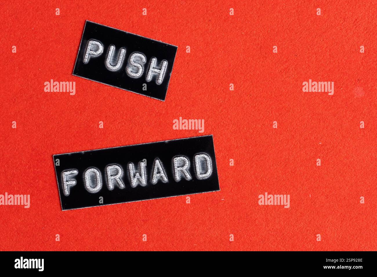 Push forward, word printed on black and white paper with red background. Concept of motivation Stock Photo