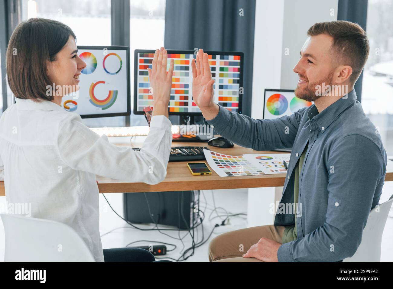 Giving high five. Two designers working together in the office Stock ...