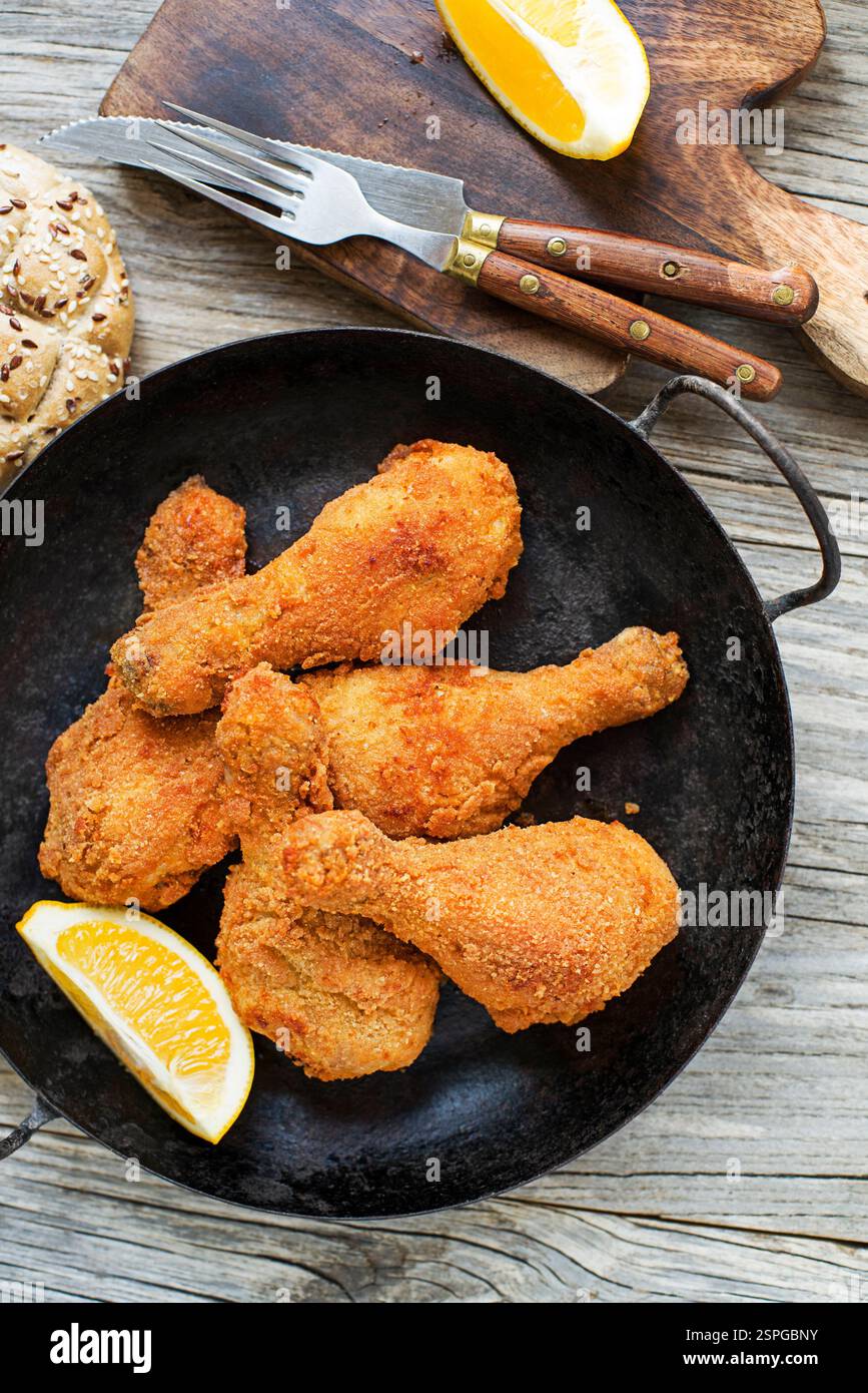 Fried crispy chicken legs, drumstick in a pan. Top view. Crispy, golden-brown fried chicken drumstick Stock Photo