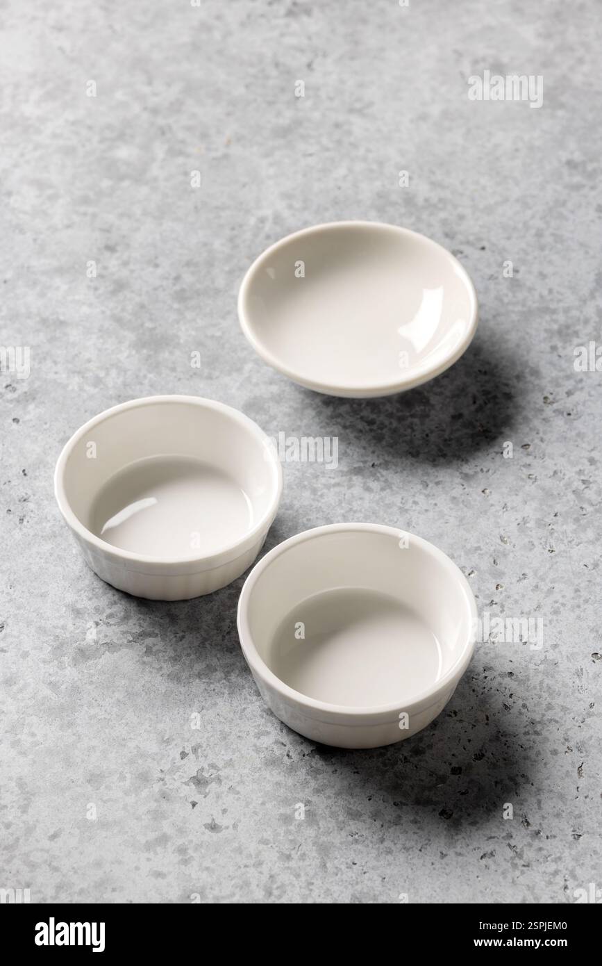 empty clean bowls on grey kitchen table background Stock Photo