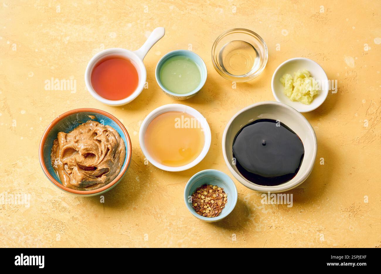 various salad dressing ingredients on yellow table background Stock Photo
