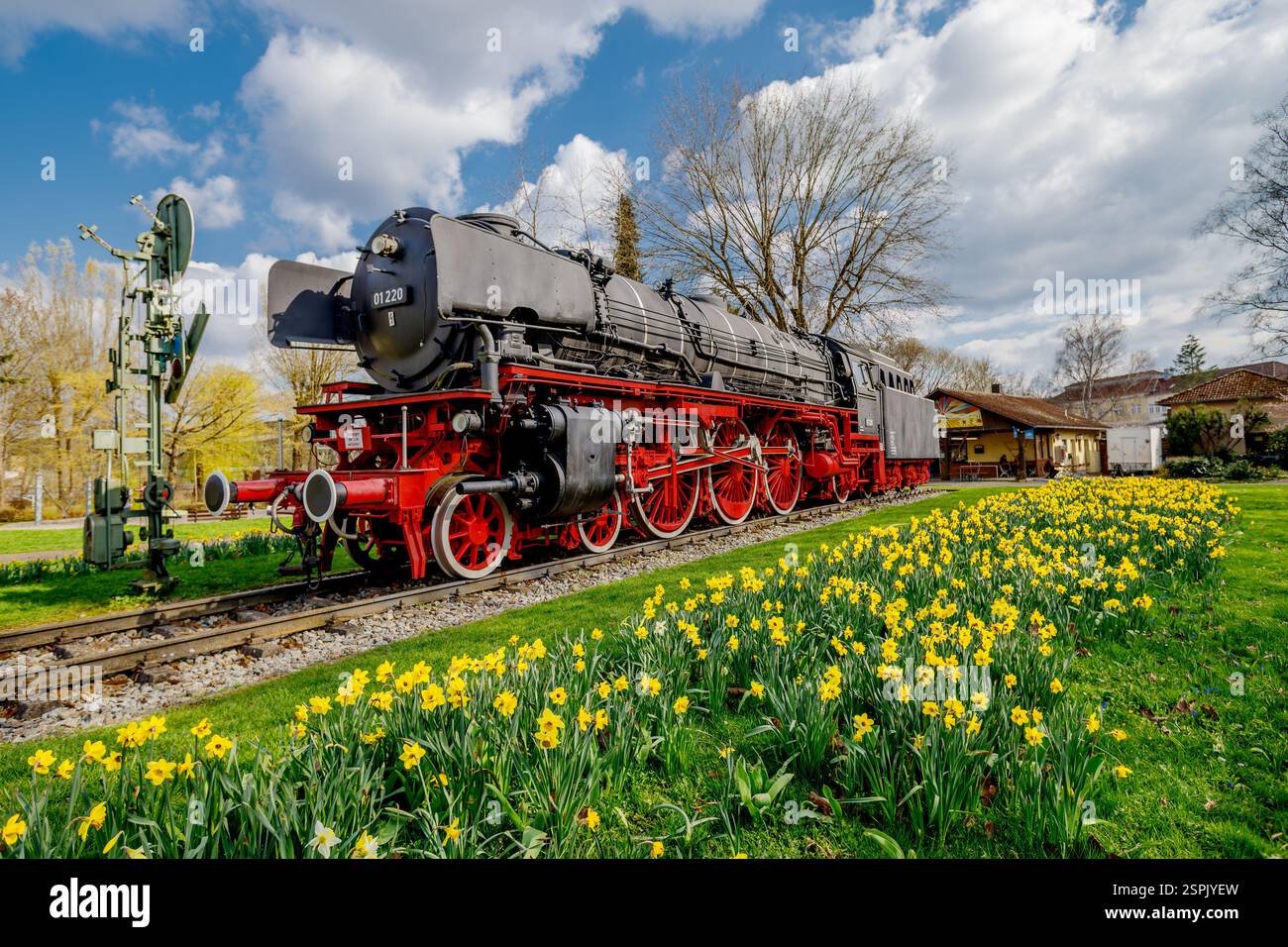 A black and red steam locomotive, number 01 220, sits on a track ...