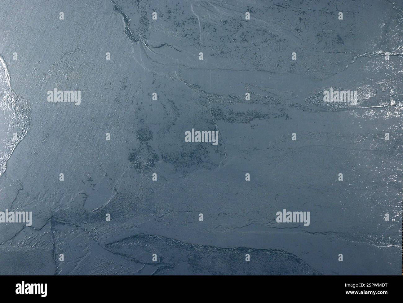 Blue background throughout the frame with a rough surface. Stock Photo