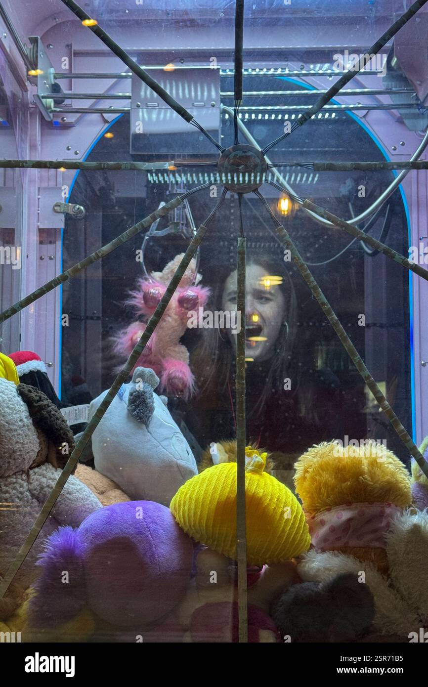 A girl catches a toy using a claw machine in Serbian industrial town of