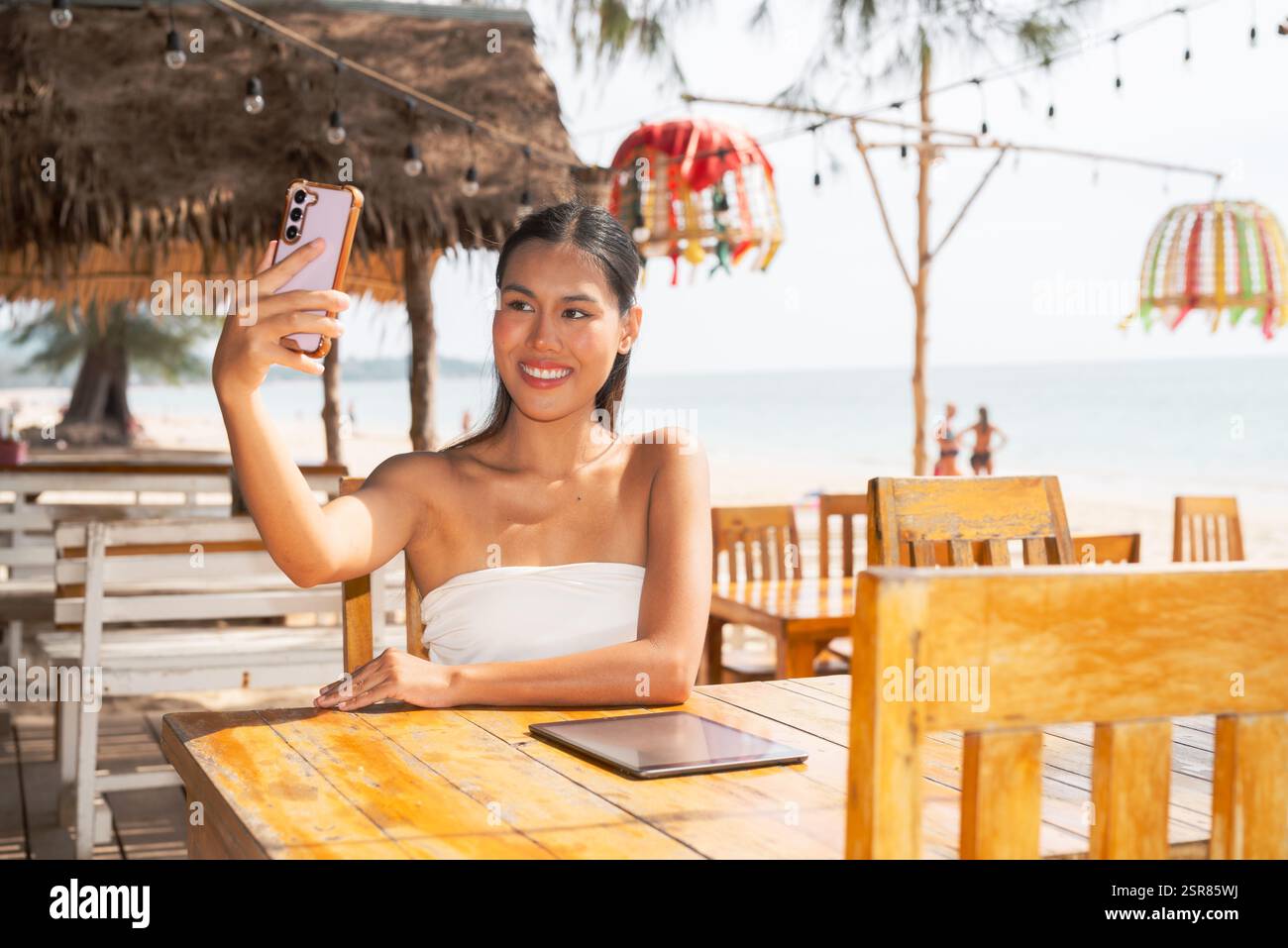 Young woman relaxing on the beach taking selfie while smiling Stock ...