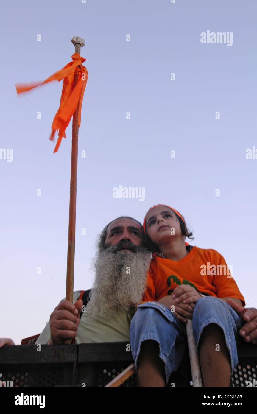 A Right wing supporter holds a stick tied with orange ribbon ...