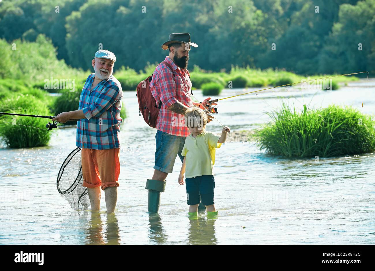 Father teaching his son fishing against view of river and landscape ...