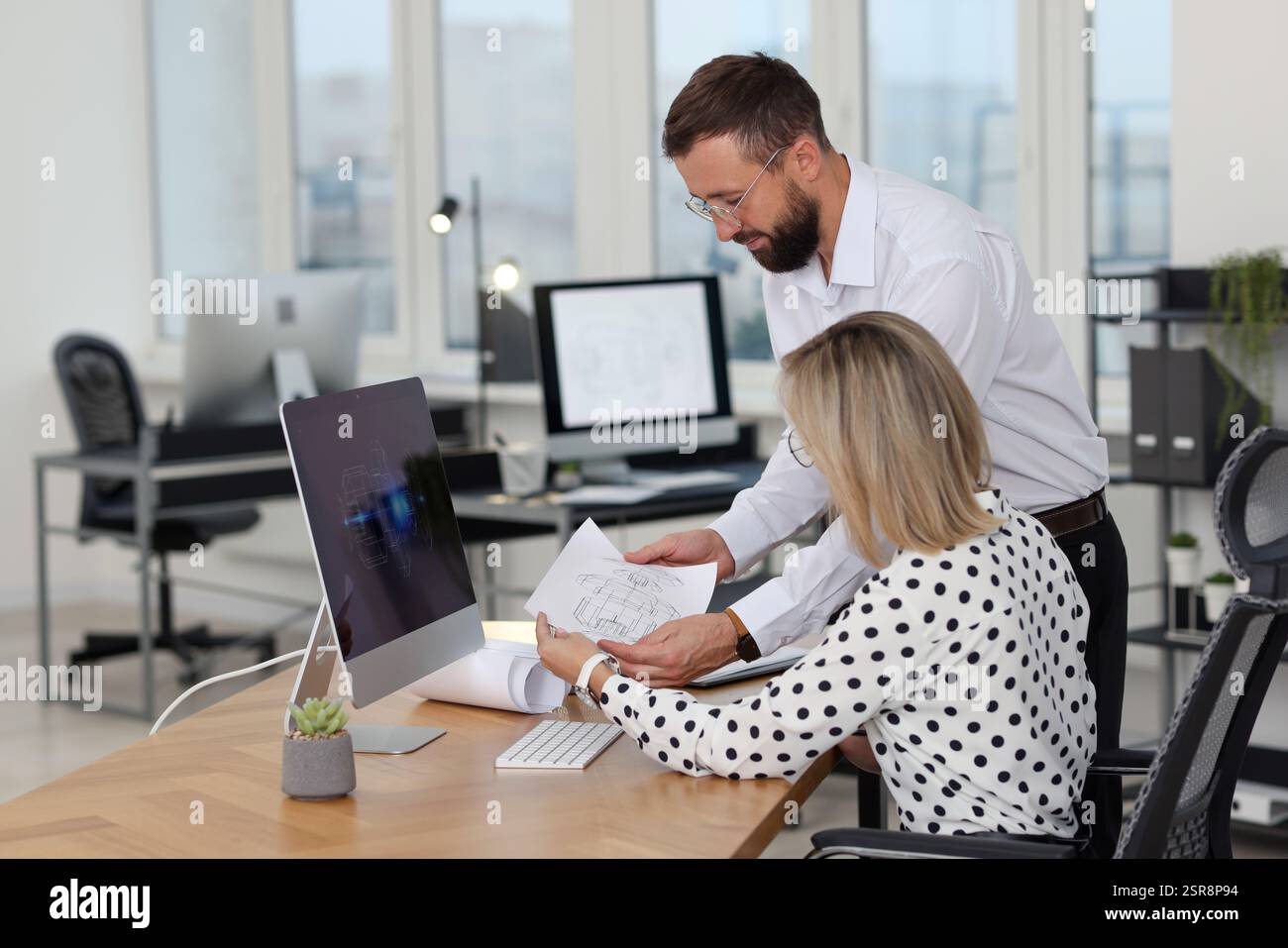 Technicians making digital engineering drawing on computer at desk in office Stock Photo