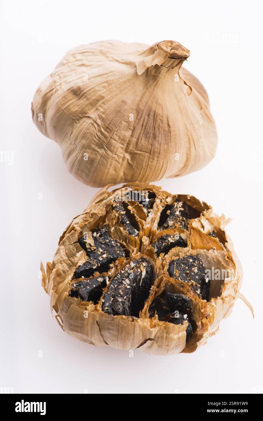 Black garlic cloves isolated on white background Stock Photo