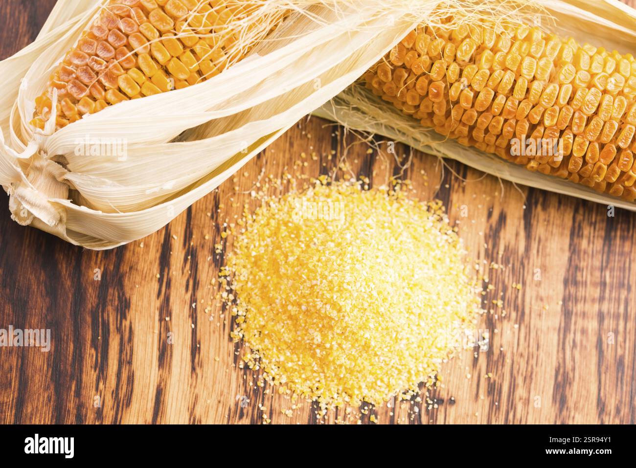 Corn groats and seeds, corncobs on wooden rustic table Stock Photo