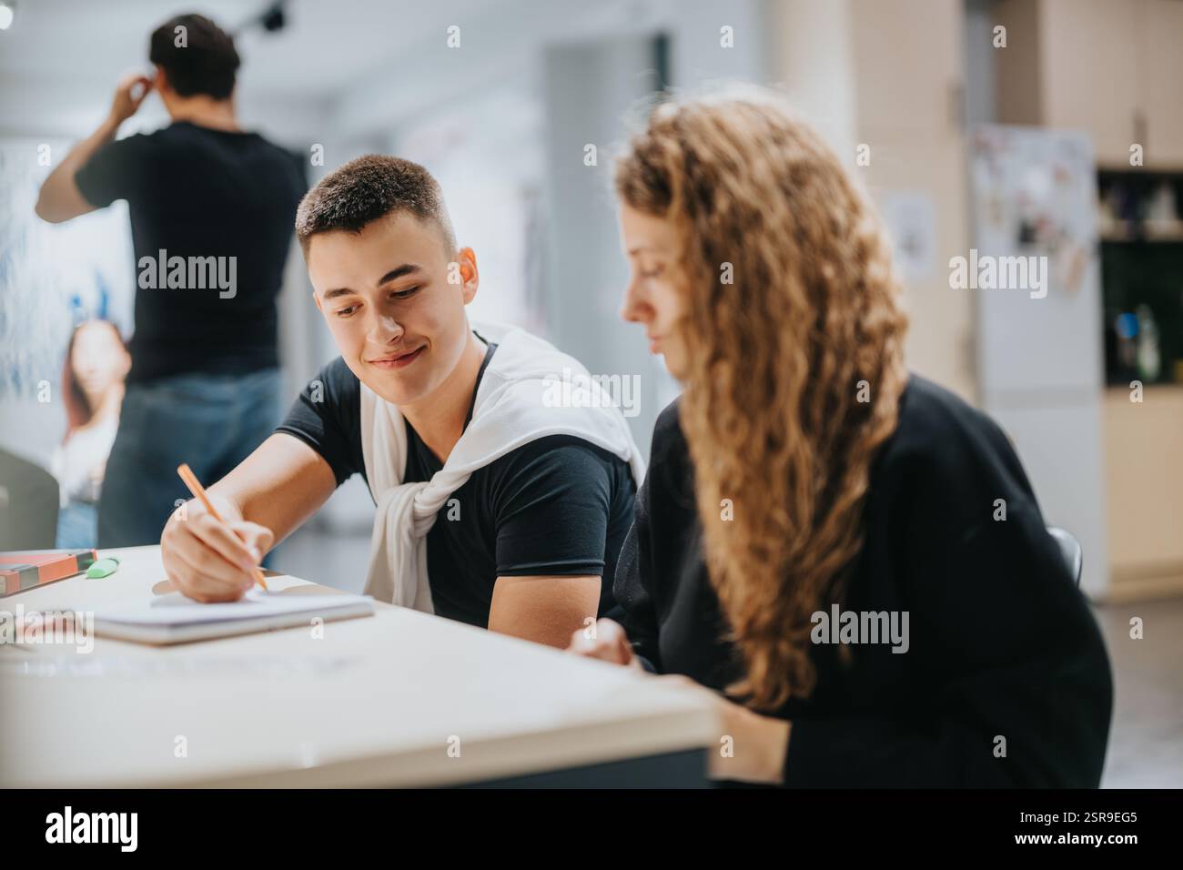 Students collaborating on group assignment in a modern classroom setting Stock Photo