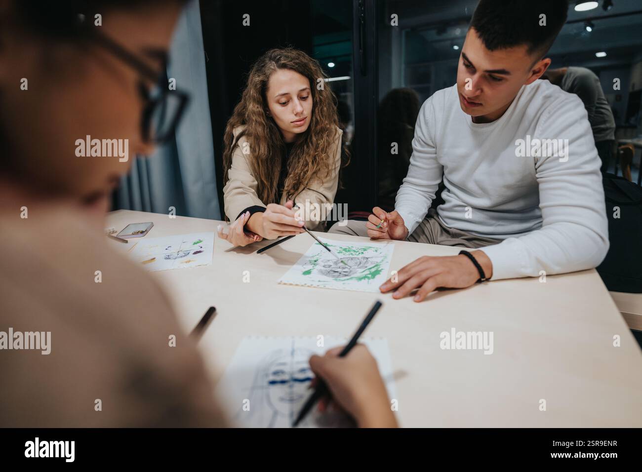 Students collaborating on an art project in the classroom Stock Photo