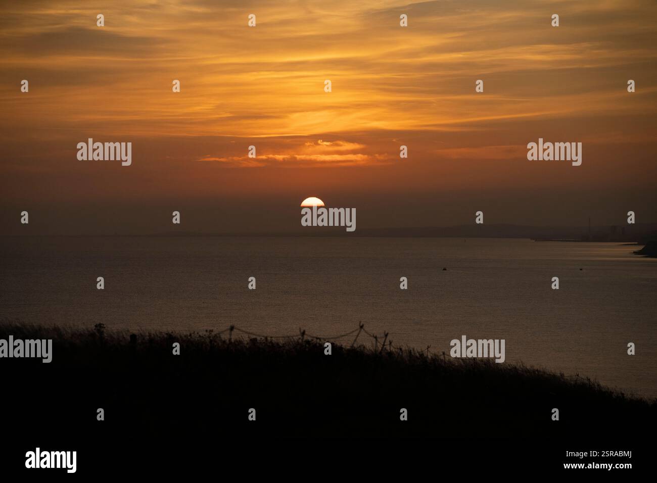 Sun setting over water. Stock Photo