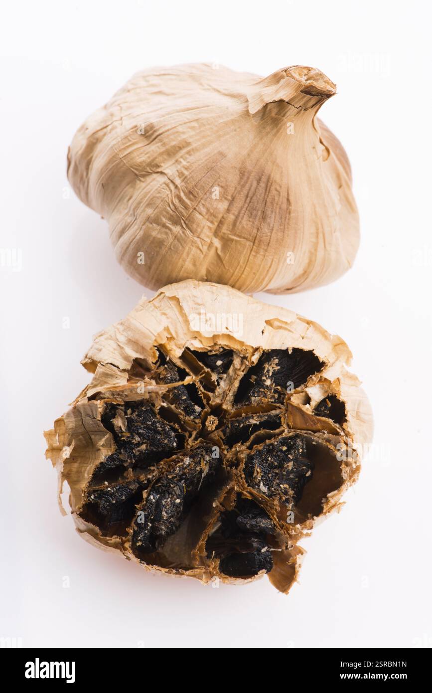 Black garlic cloves isolated on white background Stock Photo - Alamy