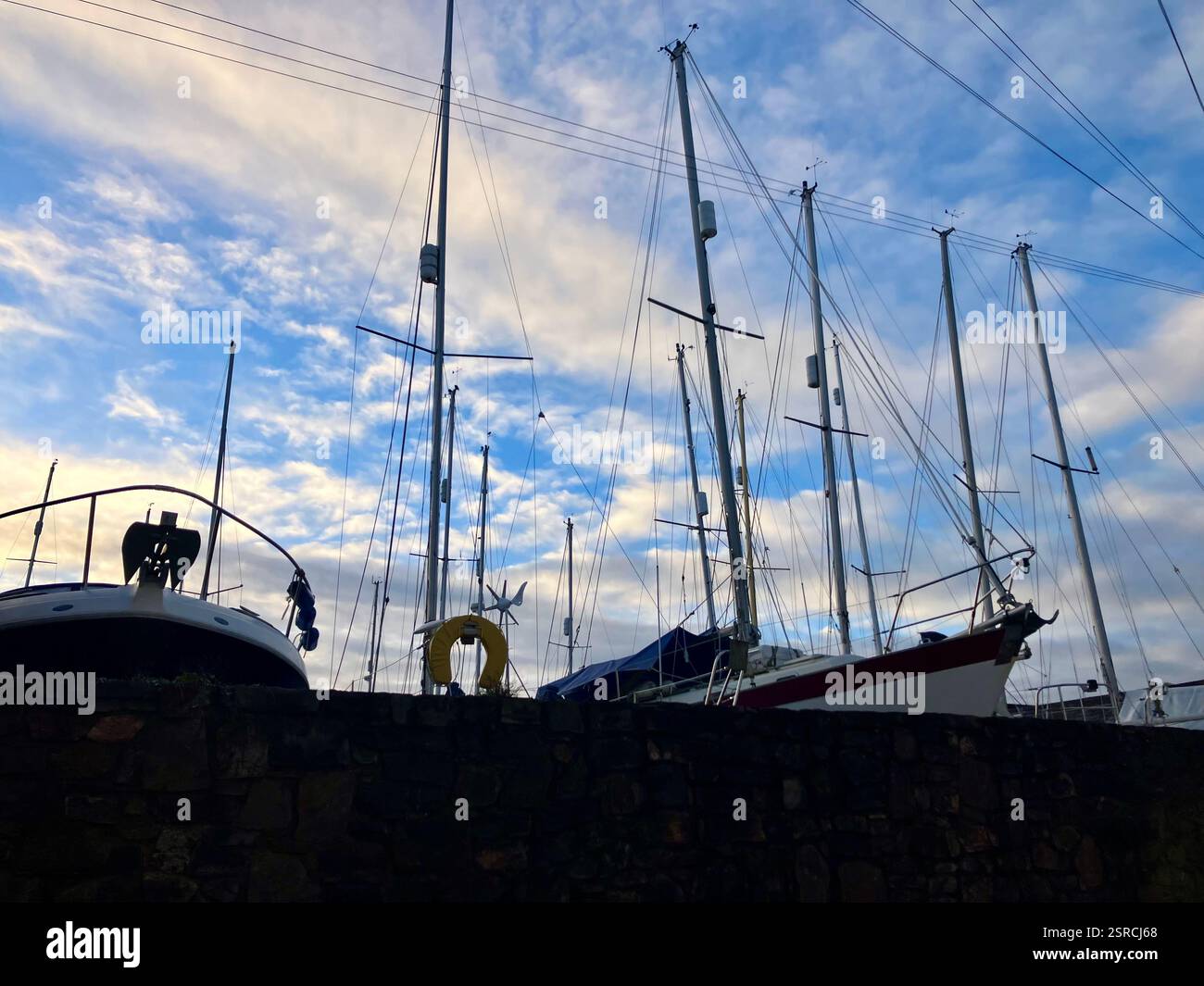 Sailing Boat Masts Against the Backdrop of a Blue, Cloudy Sky - Smartphone Captured Stock Image