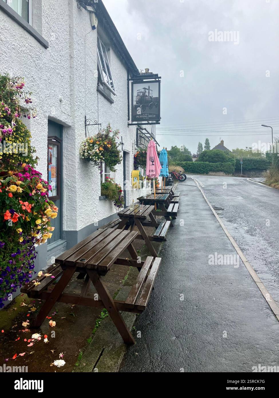 Tables, Benches and Umbrellas outside the Puffing Billy, a well loved, traditional Devon pub on the Exe Valley Trail - Smartphone Captured Stock Image