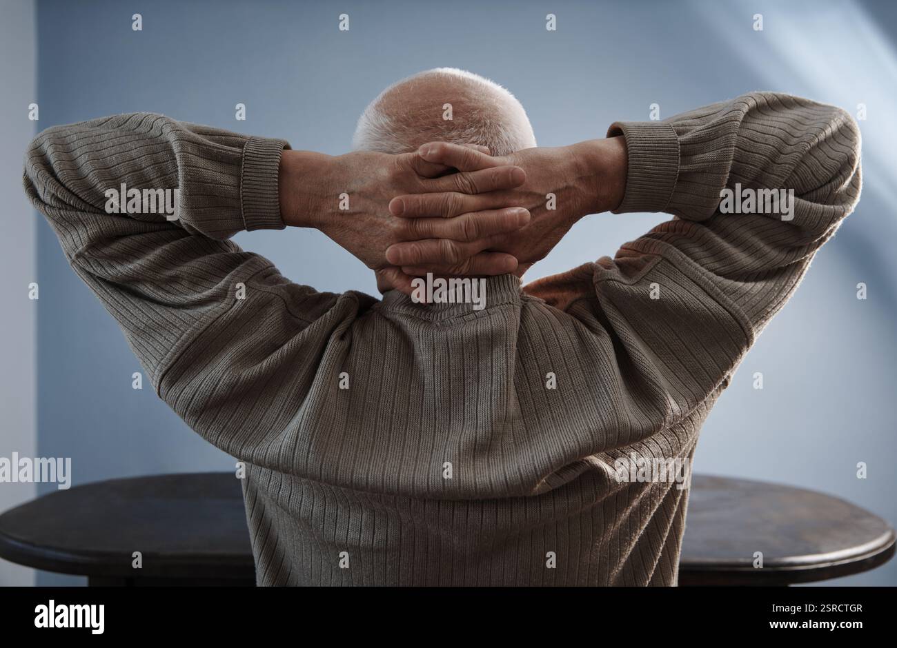 Senior man relaxing and sitting with hands behind head Stock Photo