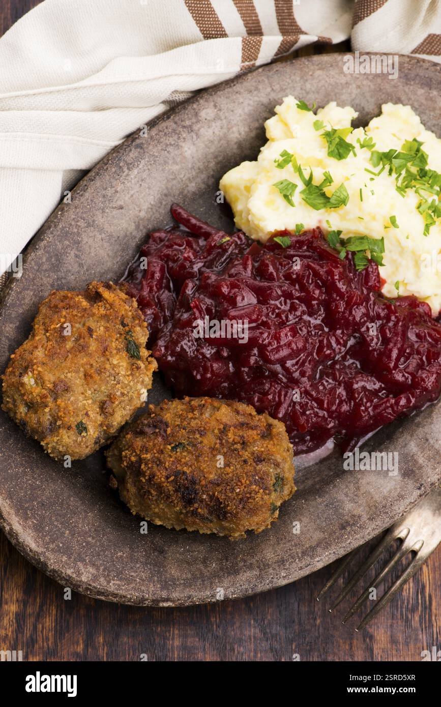 Prepared dinner on the plate. Melted meat, potatoes, beetroot Stock Photo