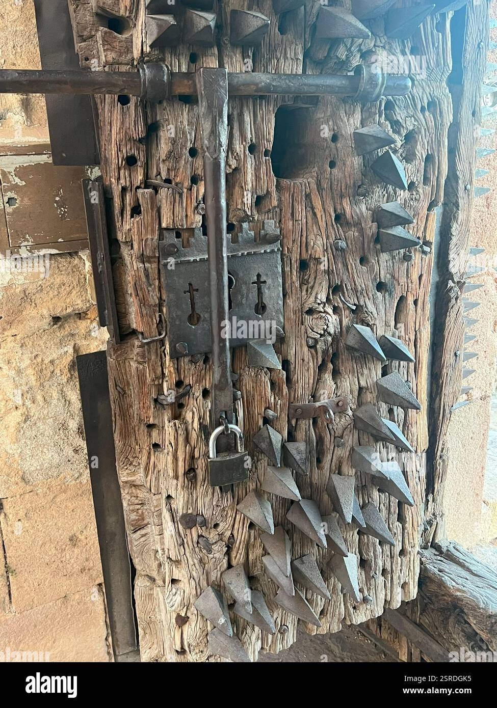 Close-up of a medieval iron lock with spikes on an old wooden door in a historic European castle - Smartphone Captured Stock Image