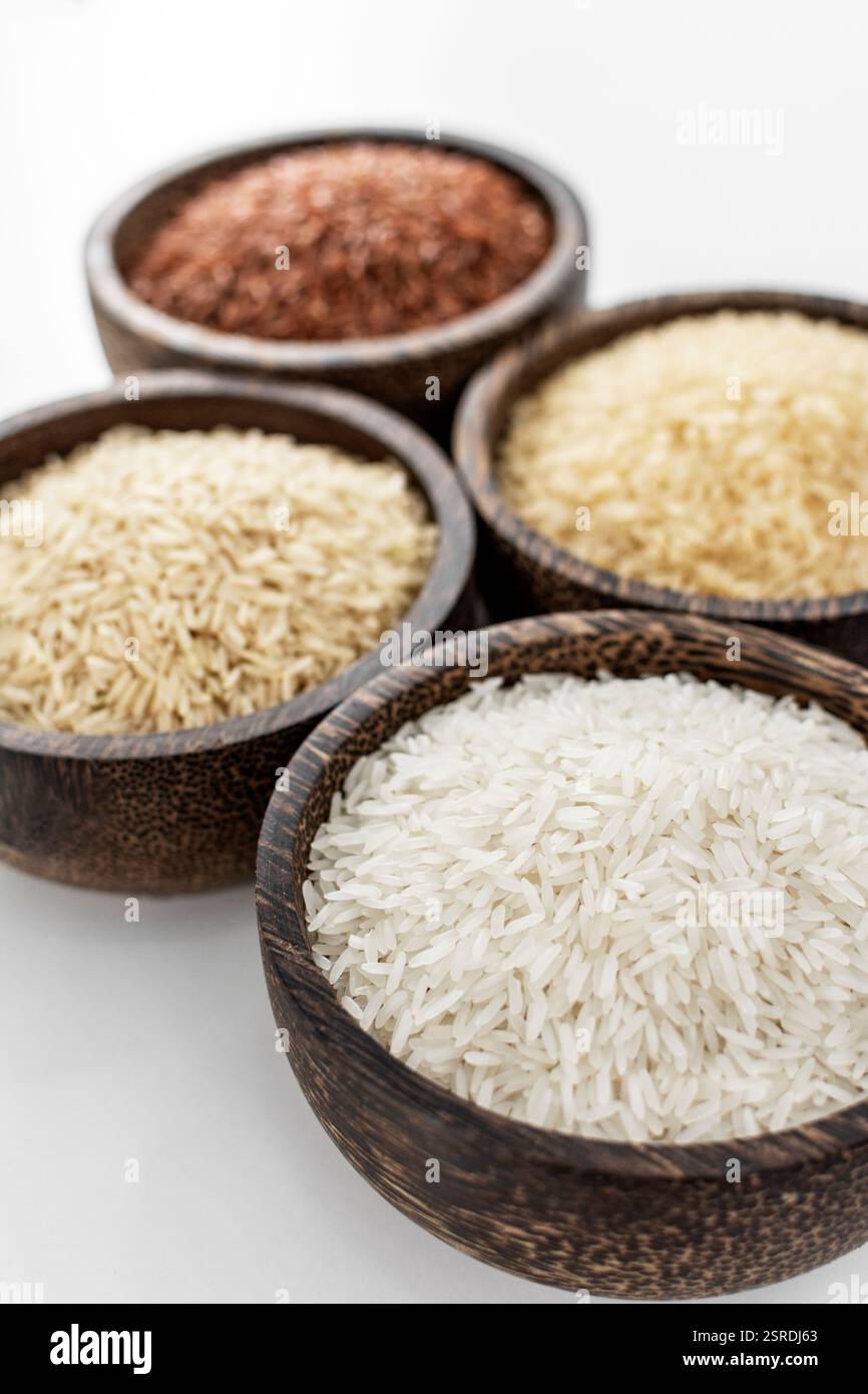 different kinds of asian rice grains in bowls on white background in ...
