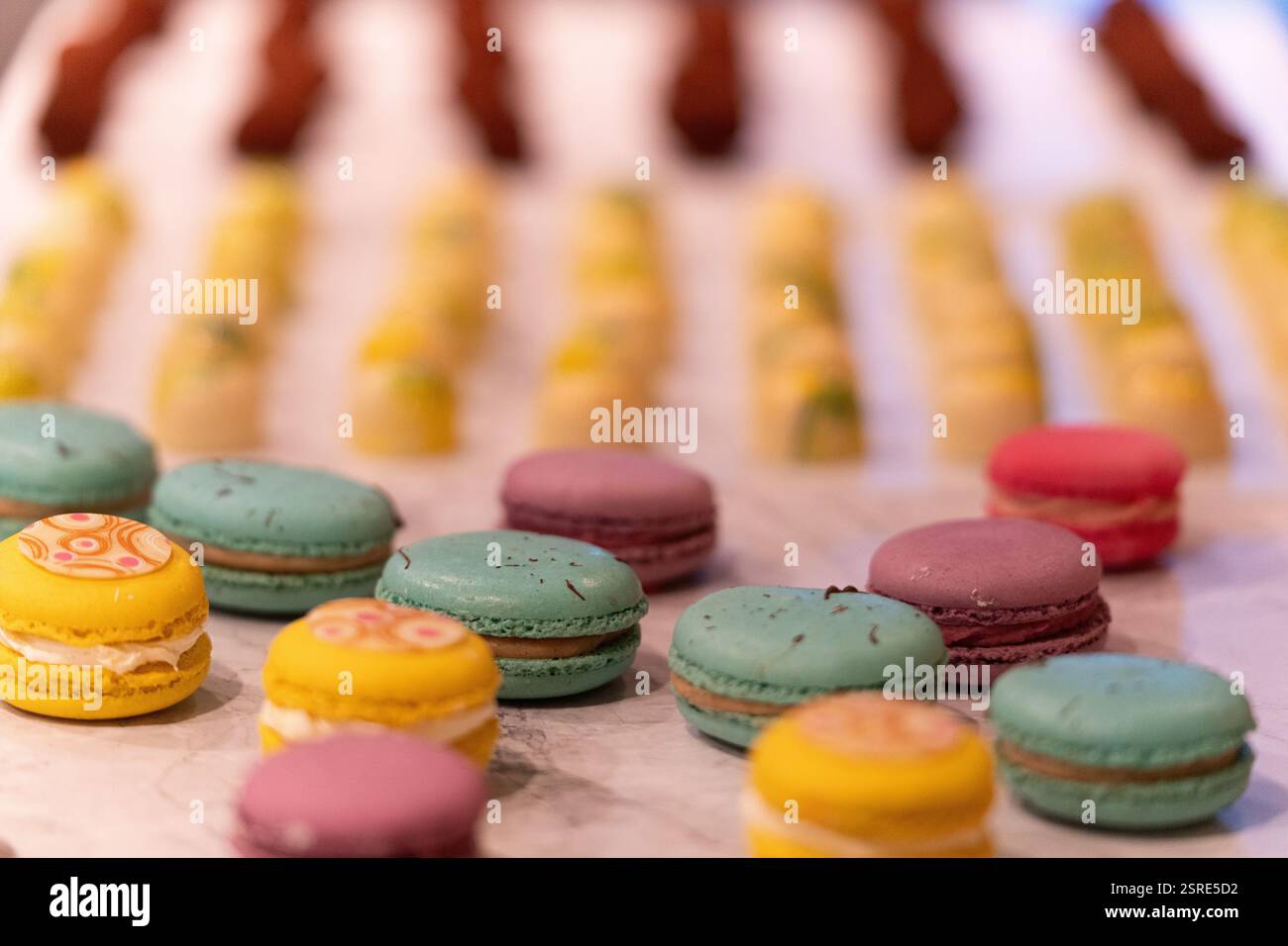 Colorful macarons, various flavors, displayed for a party. Stock Photo