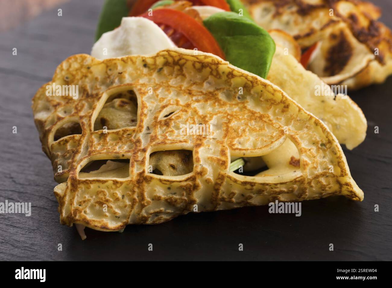Pancakes sutffed with ham, cheese, tomatoes and spinach Stock Photo