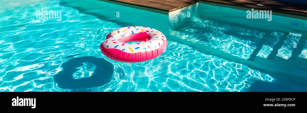 Pink donut inflatable float in turquoise swimming pool with shadow ...