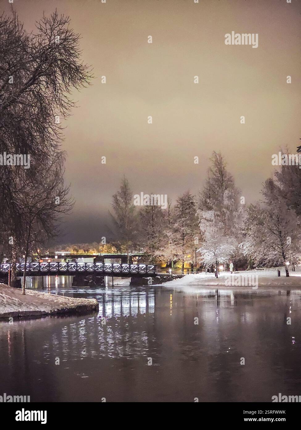 Winter landscape at city park with lake, trees and bridge - Smartphone Captured Stock Image
