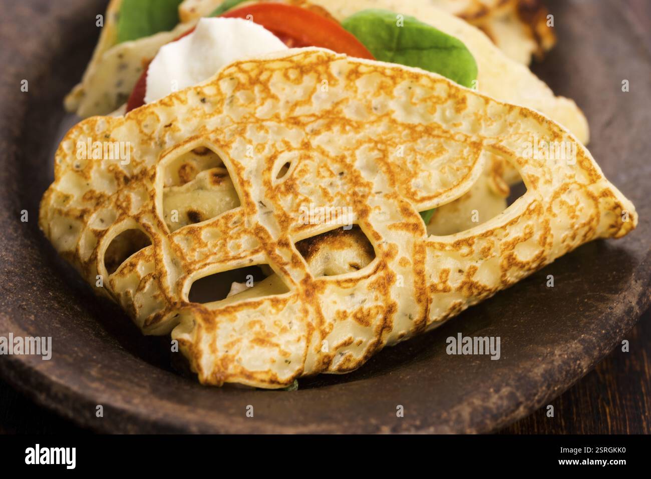 Pancakes sutffed with ham, cheese, tomatoes and spinach Stock Photo